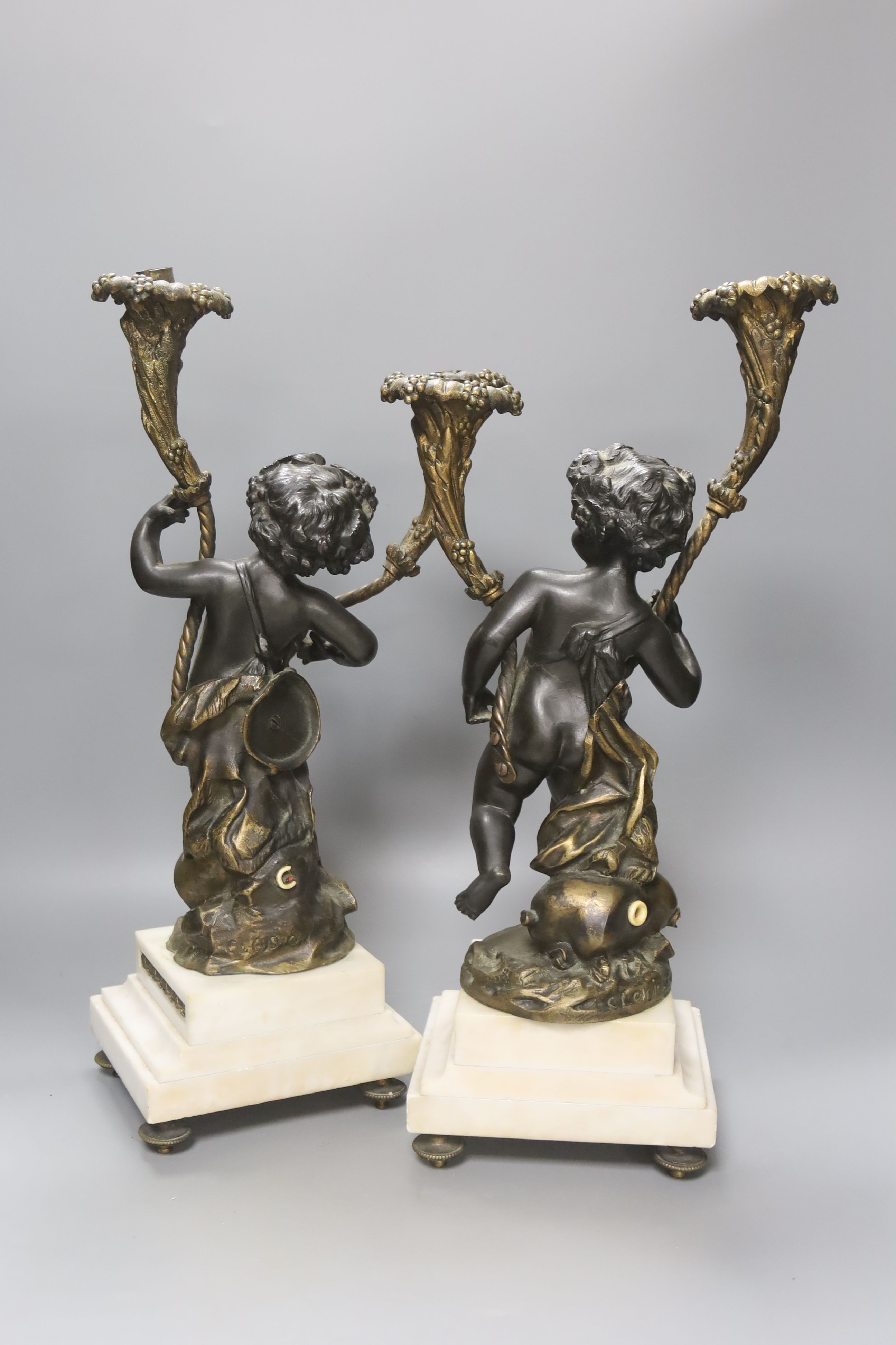 After Clodion. A pair of bronze cherub candelabra on marble bases, converted to lamps, height 42cm